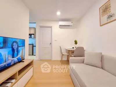 Modern living room with cozy sofa and wall-mounted TV in a stylish apartment.