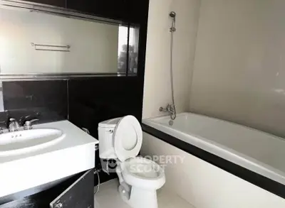 Modern bathroom with sleek design featuring bathtub and elegant fixtures.
