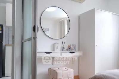 Chic modern bedroom with stylish round mirror and sleek white furniture, perfect for urban living.