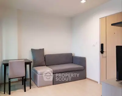 Modern living room with sleek gray sofa and compact dining area, perfect for urban living.