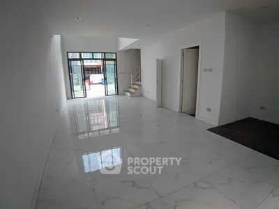 Spacious modern living room with marble flooring and large glass doors