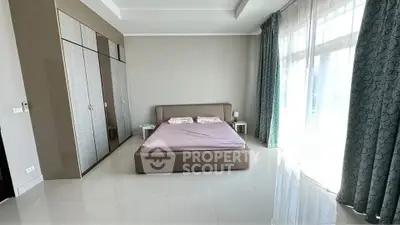 Spacious bedroom with large windows and modern decor