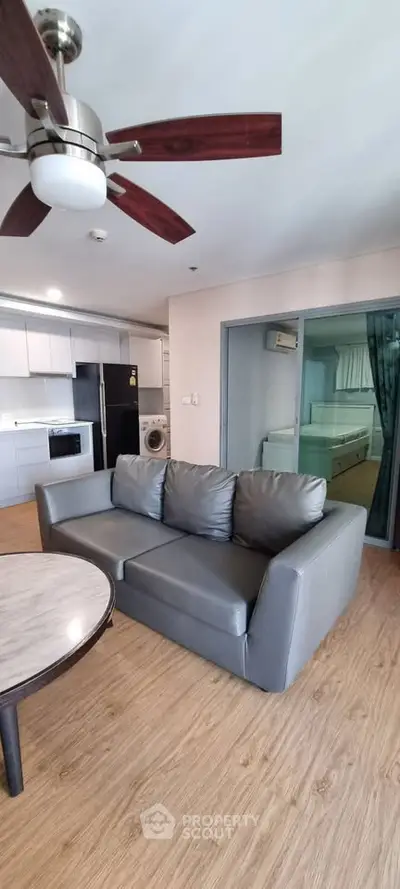 Modern living room with sleek furniture and open kitchen layout in a stylish apartment.
