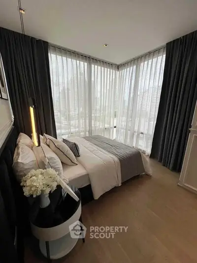 Luxurious corner bedroom with floor-to-ceiling windows and elegant decor in modern apartment.