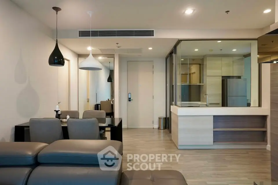 Modern open-plan living room with sleek furniture and contemporary lighting in a stylish apartment.