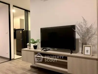 Modern living room with sleek TV stand and open kitchen view