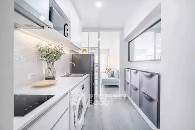 Modern kitchen with sleek appliances and open layout, featuring a washing machine and stylish decor.