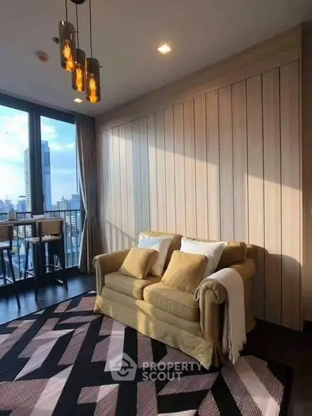 Stylish living room with city view, cozy sofa, and modern lighting in high-rise apartment.