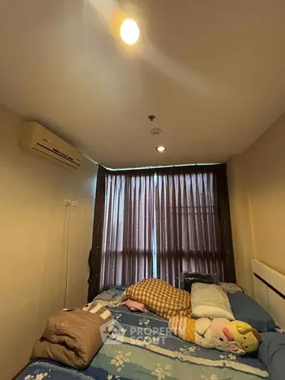 Cozy bedroom with air conditioning and large window, perfect for relaxation.