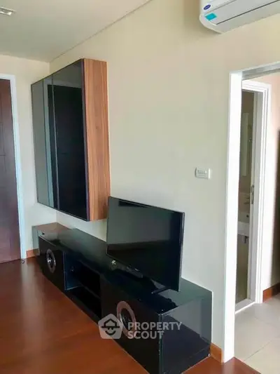 Modern living room with sleek entertainment unit and wall-mounted TV in stylish apartment.
