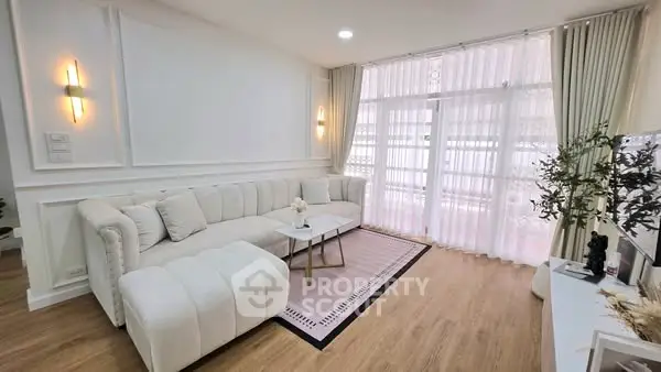 Elegant living room with plush white sofa and natural light