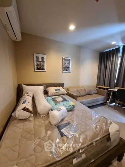 Cozy bedroom with modern decor, featuring a comfortable bed, stylish sofa, and elegant wall art.