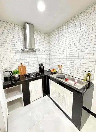 Modern kitchen with sleek black countertops and white subway tile backsplash