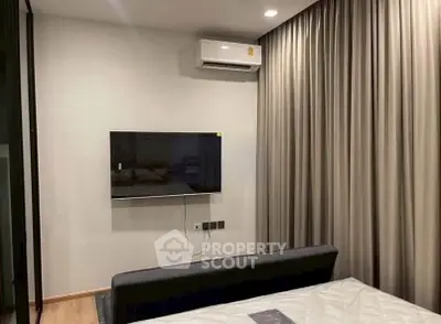 Modern bedroom with wall-mounted TV and air conditioning, featuring elegant curtains and sleek design.