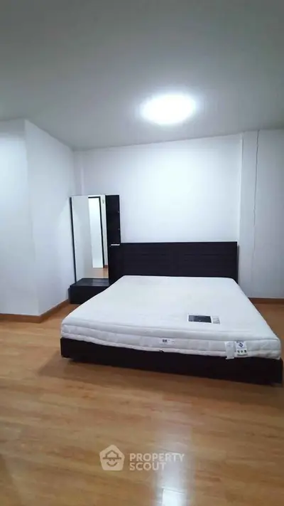 Spacious bedroom with modern furniture and wooden flooring