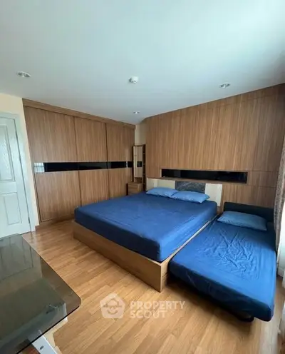 Spacious bedroom with modern wooden accents and ample natural light