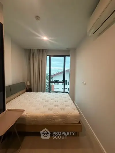 Cozy bedroom with large window offering a scenic view, featuring a comfortable bed and modern air conditioning.