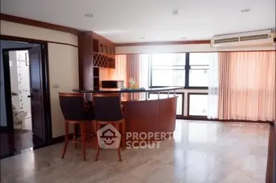 Spacious living room with elegant bar area and large windows in modern apartment.