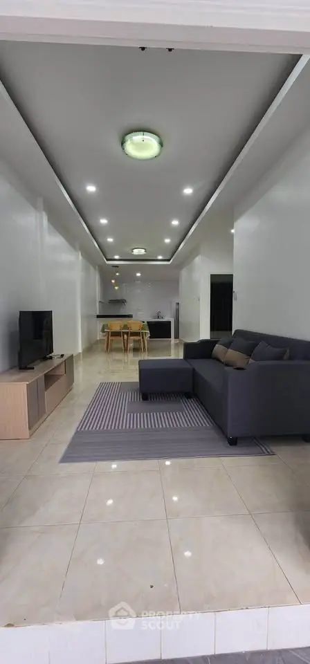 Spacious open-plan living room with modern kitchen and cozy seating area.