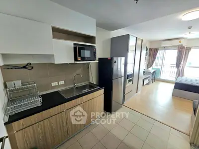 Modern studio apartment with open kitchen and balcony view