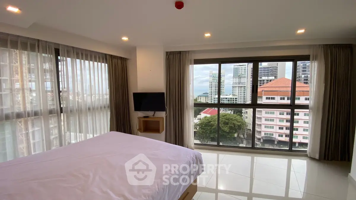 Spacious bedroom with panoramic city view and modern decor