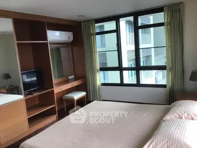 Spacious bedroom with large windows and built-in storage in modern apartment