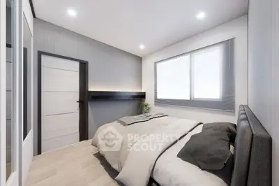 Modern bedroom with minimalist design and large window for natural light.