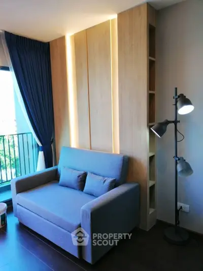 Modern living room with stylish sofa and floor lamp, featuring elegant wooden paneling and natural light.