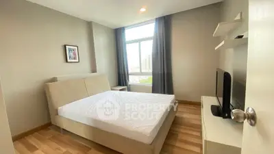 Modern bedroom with large window and stylish decor in a high-rise apartment.