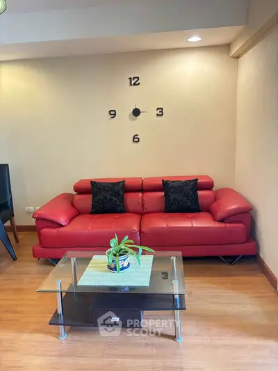 Stylish living room with red leather sofa and modern wall clock