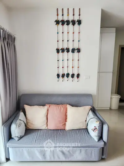 Cozy living room with stylish sofa and decorative wall art, perfect for modern urban living.