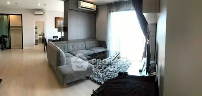 Spacious modern living room with elegant gray sofa and natural light