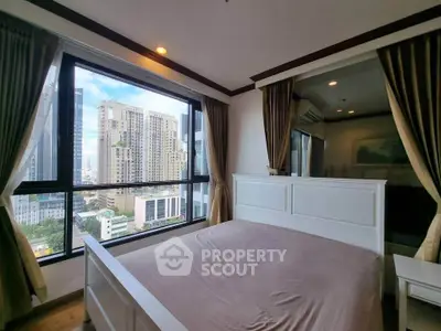 Spacious bedroom with large window offering stunning city views in modern high-rise apartment.