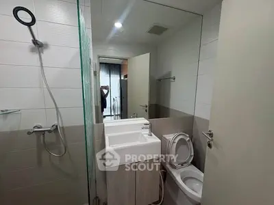 Modern bathroom with sleek fixtures and glass shower partition