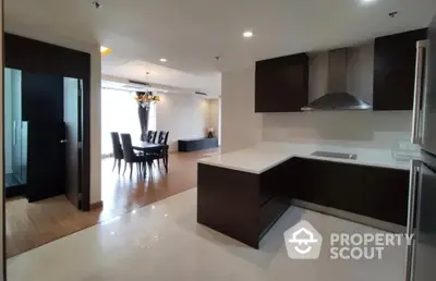 Spacious modern kitchen with open layout and dining area in luxury apartment.