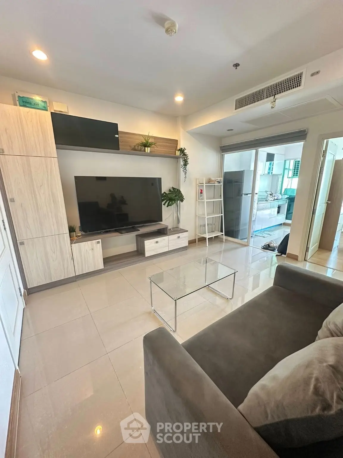 Modern living room with sleek TV setup and glass coffee table