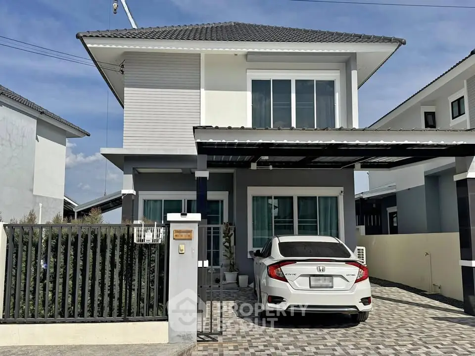 Modern two-story house with carport and sleek design in a suburban neighborhood.