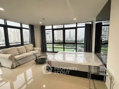 Spacious corner unit with large windows offering stunning city views, featuring a cozy living area and modern furnishings.