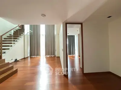 Spacious modern living room with wooden flooring and large windows