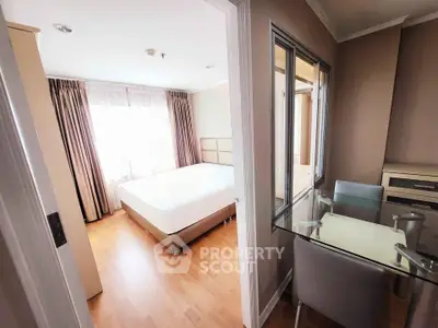 Spacious bedroom with natural light and modern furnishings in a stylish apartment.