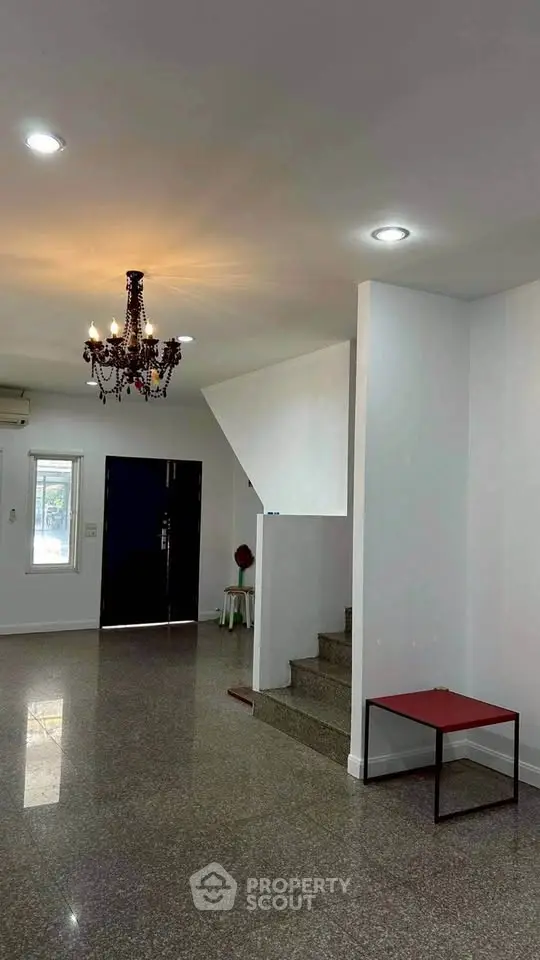 Spacious interior with elegant chandelier and modern staircase