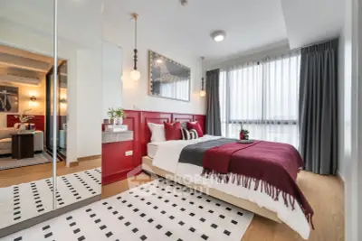 Modern bedroom with stylish decor, large window, and cozy bedding in a contemporary apartment.