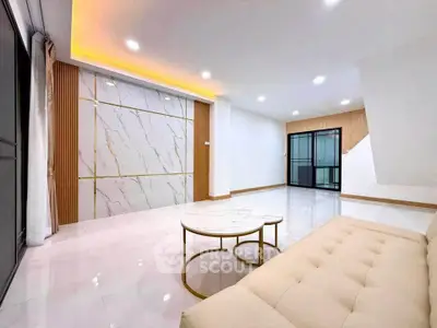 Spacious modern living room with elegant marble accent wall and cozy beige sofa.
