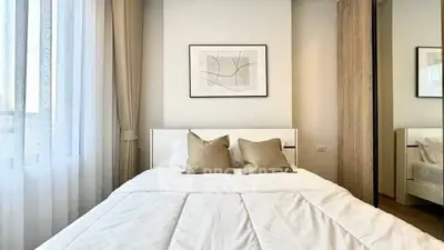 Bright and cozy bedroom with modern decor and large window for natural light.