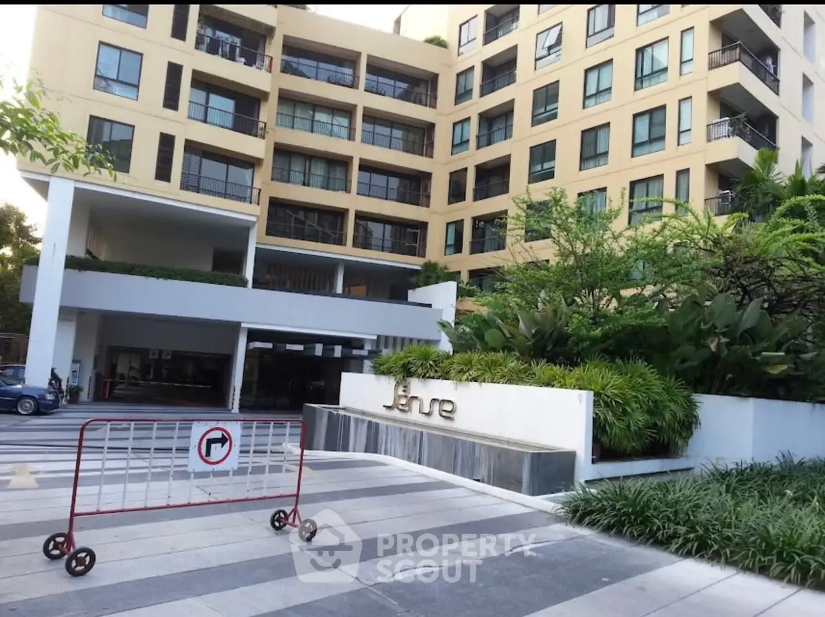 Modern apartment building exterior with lush landscaping and stylish entrance