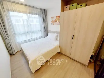 Cozy bedroom with modern wardrobe and large window for natural light