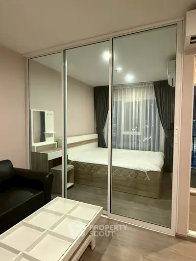 Modern bedroom with glass partition and stylish furnishings in a contemporary apartment.