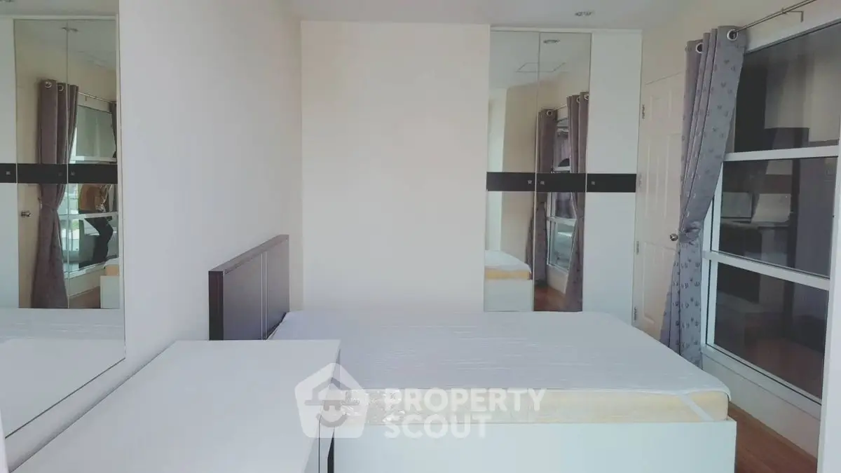 Modern bedroom with sleek mirrored wardrobe and minimalist design