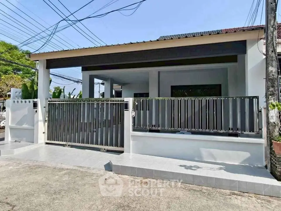 Charming single-story home with modern gated entrance and spacious driveway.