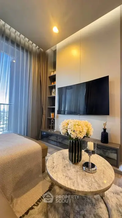 Luxurious living room with modern decor and large TV, perfect for relaxation.
